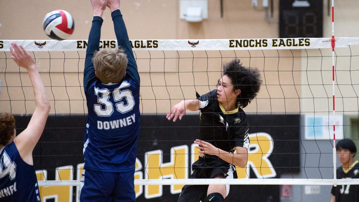 Enochs’ Andre Suico spikes the ball past Downey’s Ryder Rockwood during the Central California Athletic League match at Enochs High School in Modesto, Calif., Tuesday, April 4, 2023. Enochs won the match 3-1.