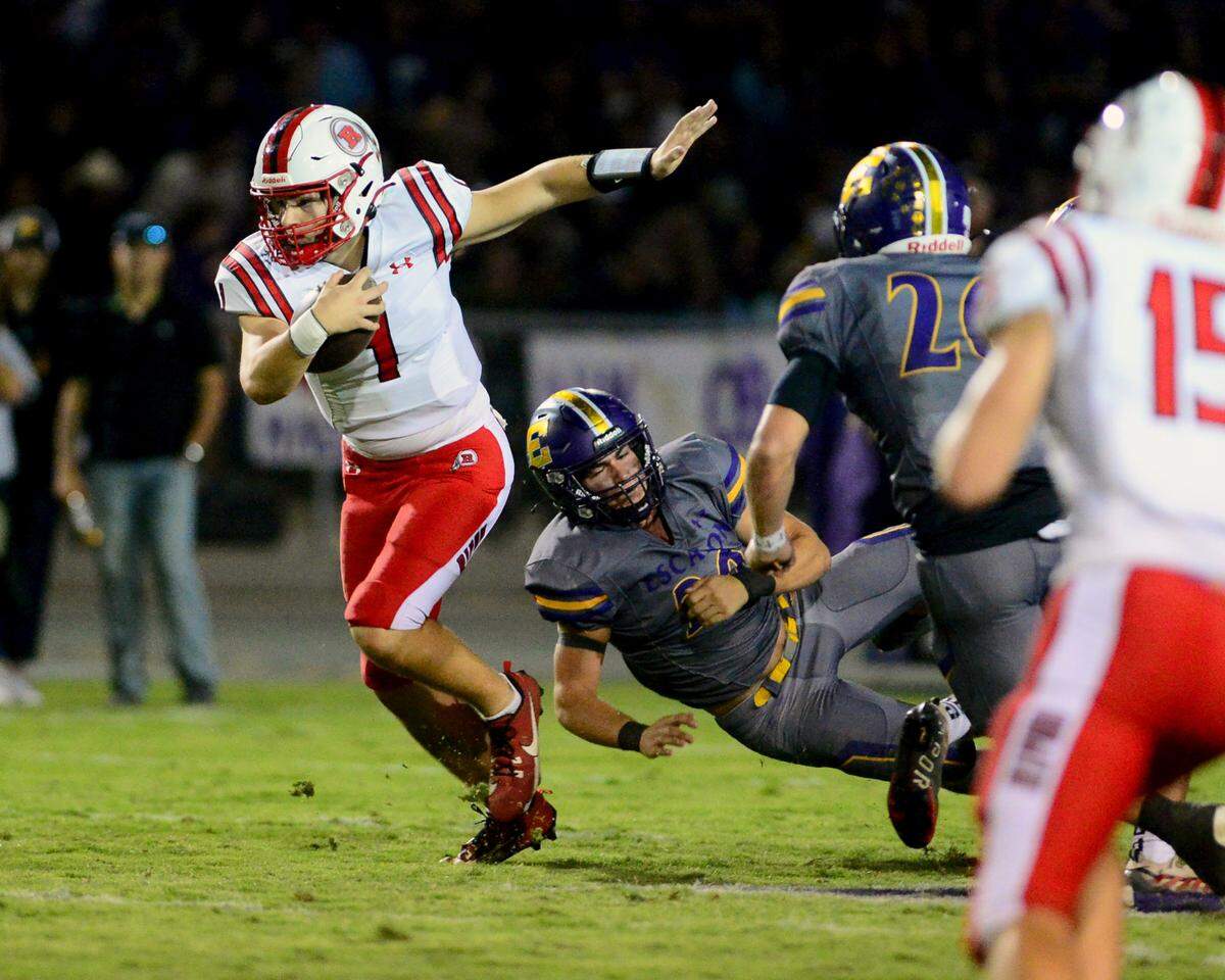 Ripon quarterback Ty Herrin (1) scrambles out of the pocket on a run during a game between Escalon High School and Ripon High School in Escalon, California on October 20, 2023. 