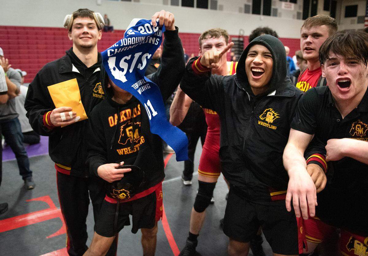 Oakdale team members celebrate their D1 championship over Vacaville in the Sac-Joaquin Section wrestling tournament at Lincoln High School in Stockton, Calif., Saturday, Jan. 28, 2023.