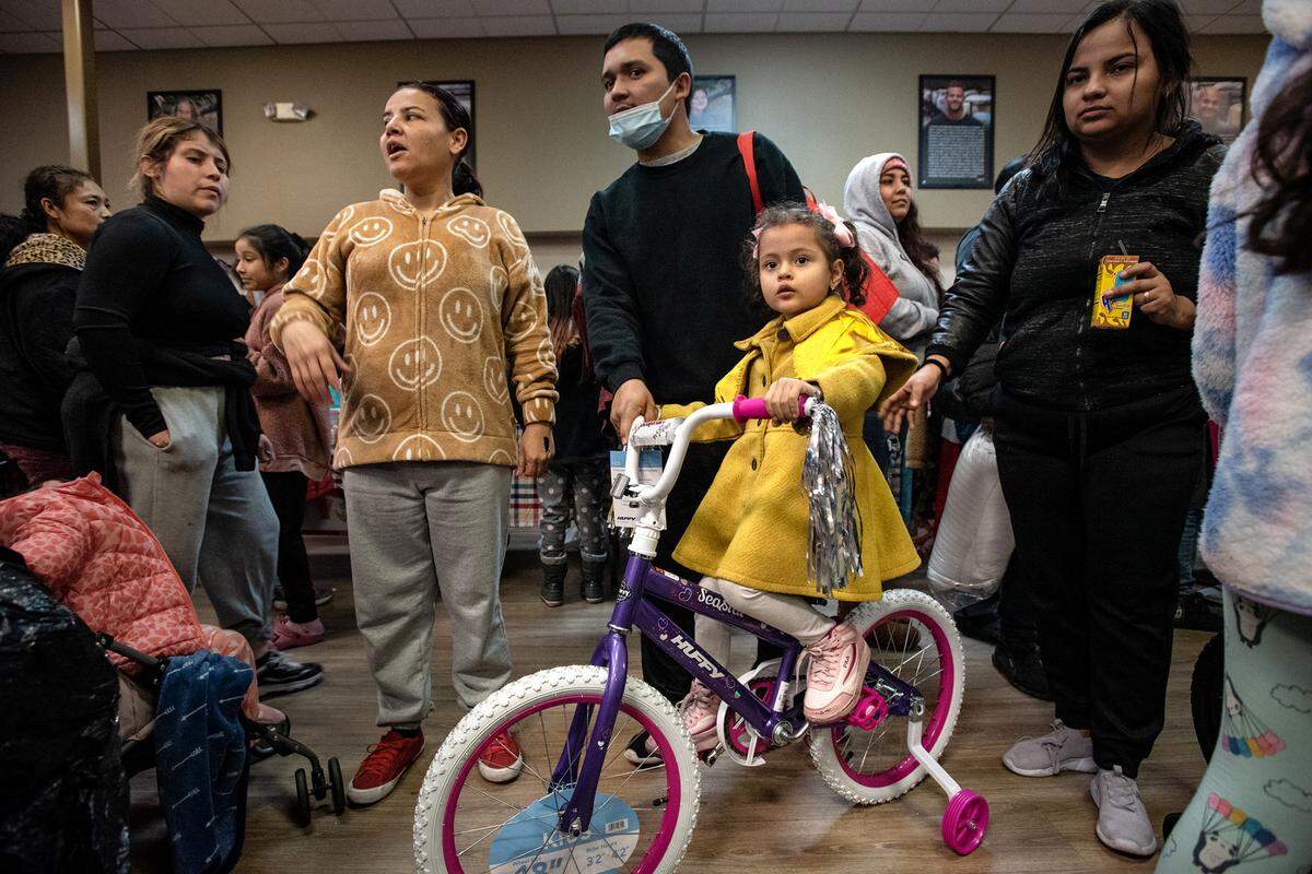 Sophia Mateus, 5, was gifted a bike during Modesto Gospel Mission’s annual Christmas gathering in Modesto, Calif., Friday, Dec. 23, 2022. She enjoyed a free holiday meal with her parents Stephanie, right, and Christian, middle.