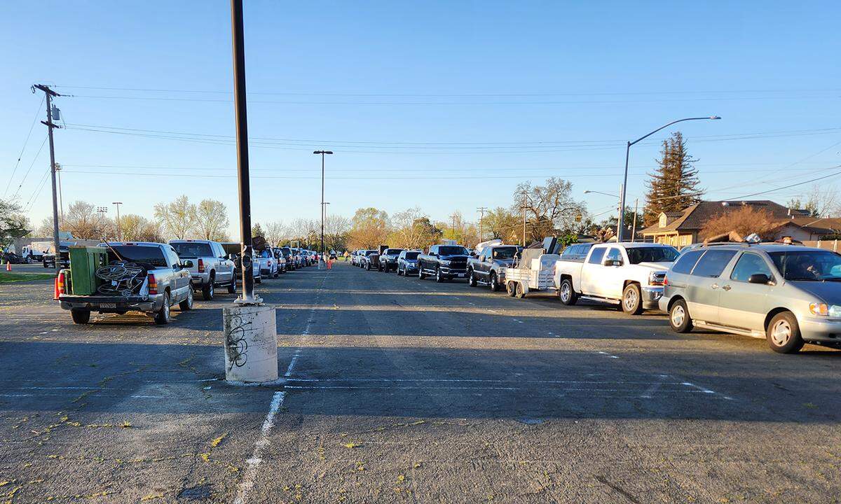 Vehicles wait in line Saturday to drop off their busted furniture, broken TVs and other bulky items Saturday at John Thurman Field.