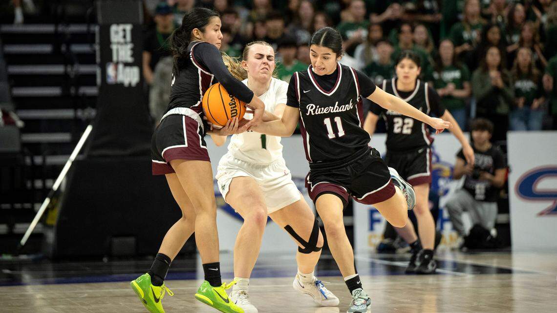 Riverbank’s Leilani Olanolan and teammate Aliyah Felix steal the ball from Liberty Ranch’s Kendall Duryee during the Sac-Joaquin Section D-4 championship game at the Golden 1 Center in Sacramento, Thursday, February, 27, 2025.
