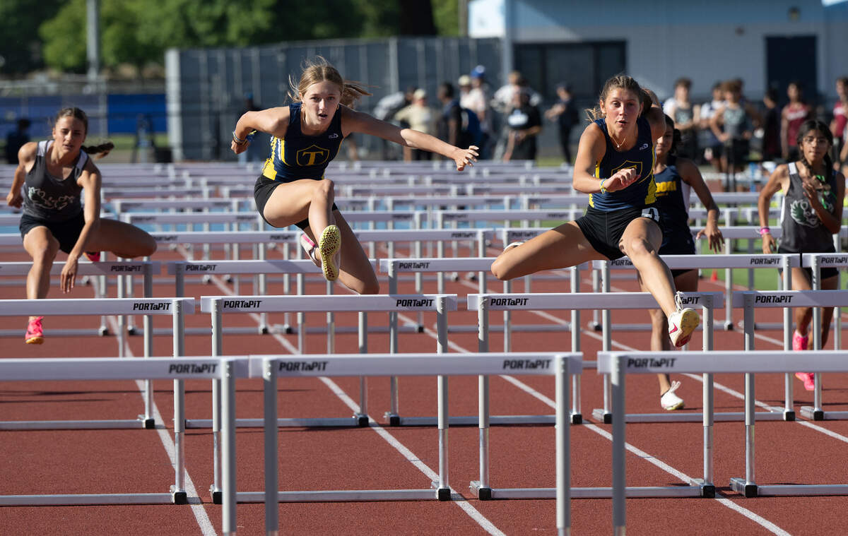 Turlock’s Cali Brem, right, edged out teammate Evelyn Ladine, left, to win the girls 100 meter hurdles with a time of 15.27 in the Central California Athletic League Championships at Downey High School in Modesto, Calif., Wednesday, May 1, 2024.