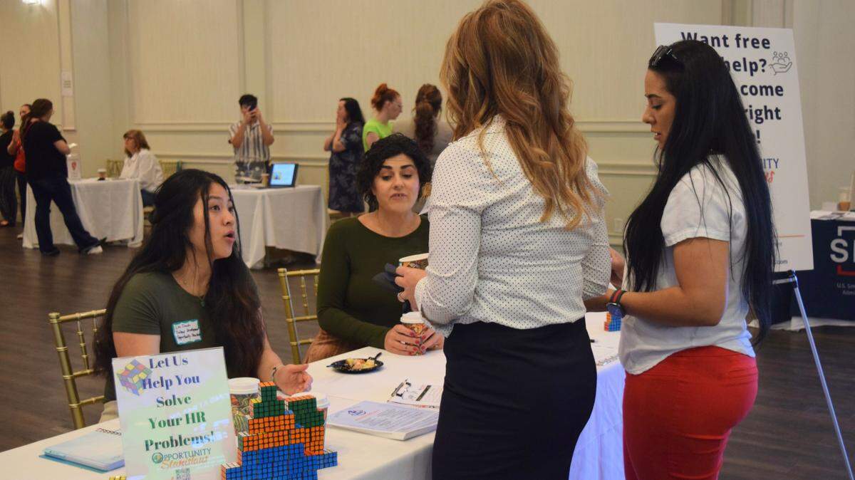 Staff from Opportunity Stanislaus talk to attendees of the Turlock Business Summit on May 24, 2022.