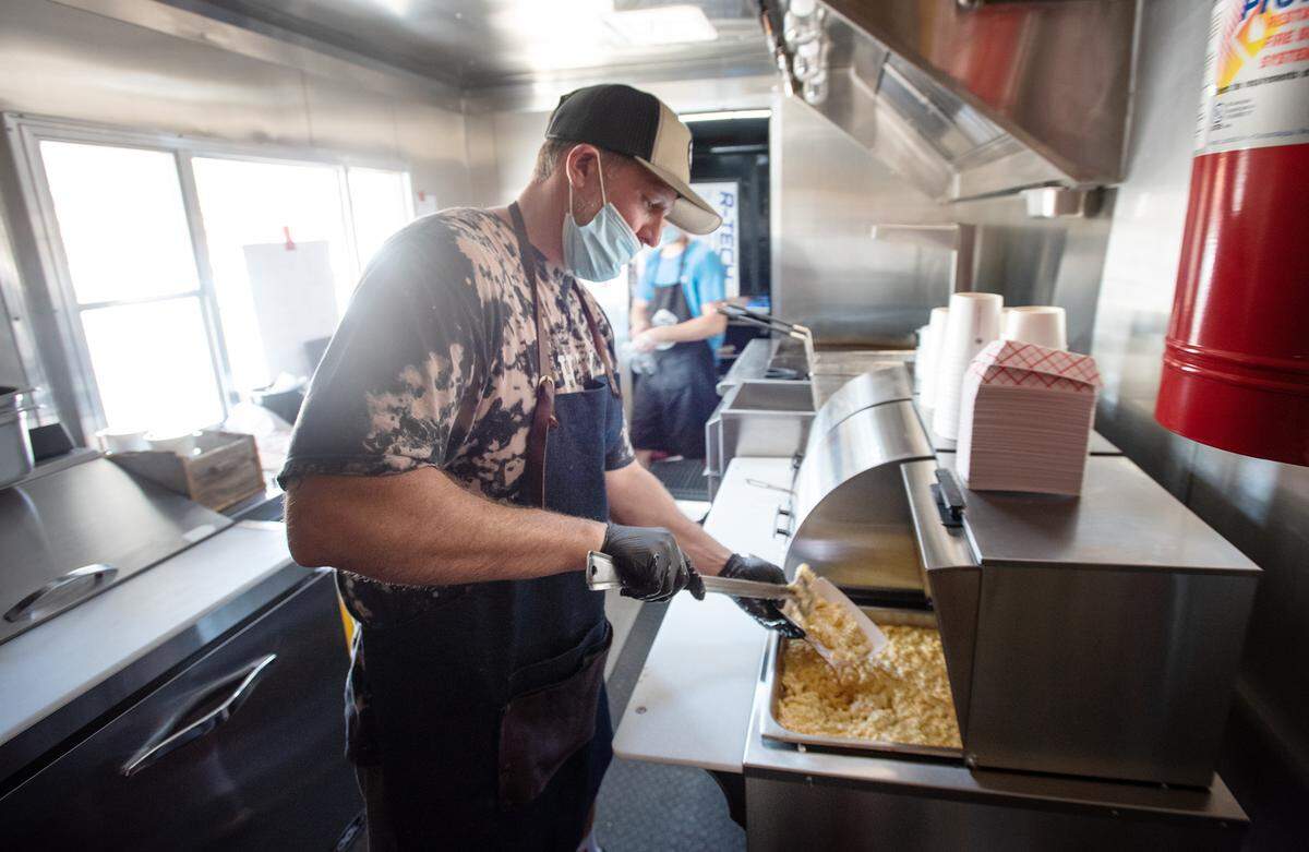 Slick Fork BBQ food truck owner Kevin Bradley serves up mac n cheese at the corner of Coffee Road and Scenic Drive in Modesto, Calif., on Saturday, August 1, 2020.