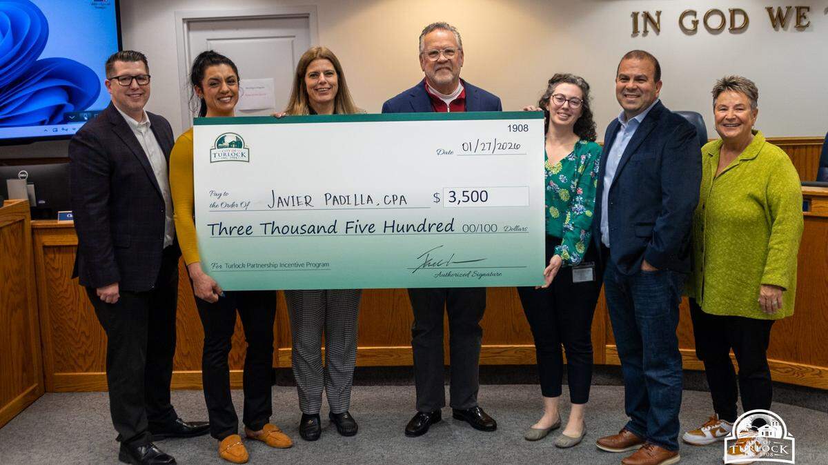 A Turlock resident receives a check for $3,500 for the city’s Partnership Incentive Program at the city council meeting on Jan. 27, 2026.
