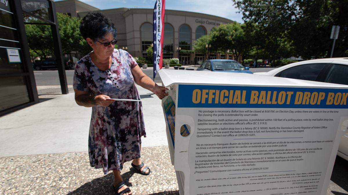 Voter Erma Cardenas drops her ballot in the drop box outside the Stanislaus County Registrar of Voters office in Modesto, Calif., on Tuesday, June 7, 2022.