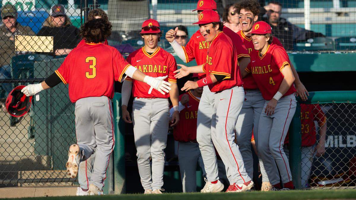 Oakdale’s Gabe McDonald and his teammates celebrate a run in the 8th inning during the Valley Oak League showcase game with Central Catholic at John Thurman Field in Modesto, Calif., Friday, March 31, 2023. Oakdale won the game 10-6.