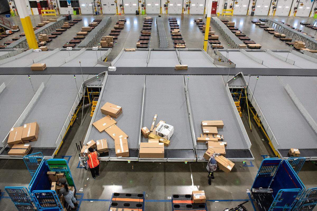 Workers sort large packages at the Amazon robotic sort center in Tracy, Calif., Thursday, Nov. 10, 2022.