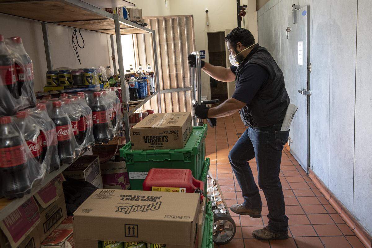 MTC Distributing driver Jose Guerrero delivers products at Oasis Market in Turlock, Calif., on Tuesday, April 14, 2020.