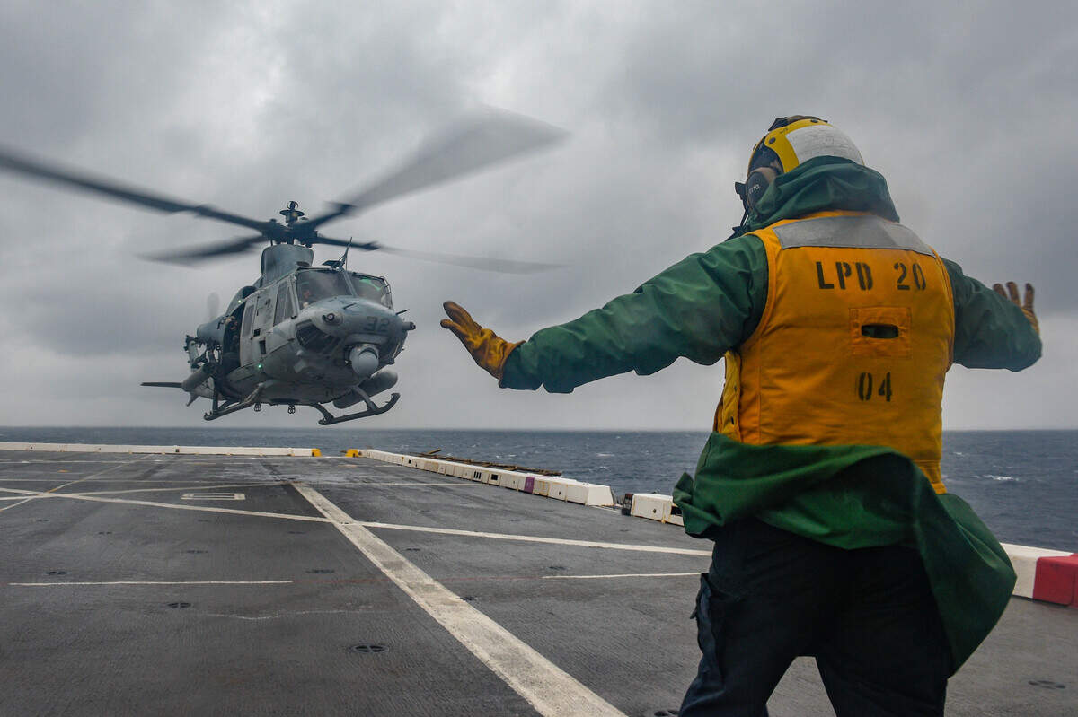 PHILIPPINE SEA (Feb. 17, 2022) Aviation Boatswain’s Mate (Handling) 2nd Class John Montano, from Oakdale, Calif., assigned to the amphibious transport dock ship USS Green Bay (LPD 20), signals a UH-1Y Huey helicopter from Marine Medium TIltrotor Squadron (VMM) 265 to take off from the flight deck. Green Bay, part of Expeditionary Strike Group 7, along with the 31st Marine Expeditionary Unit (MEU), is operating in the U.S. 7th Fleet area of responsibility to enhance interoperability with allies and partners and serve as a ready response force to defend peace and stability in the Indo-Pacific region. (U.S. Navy photo by Mass Communication Specialist 2nd Class Jonathan D. Berlier)