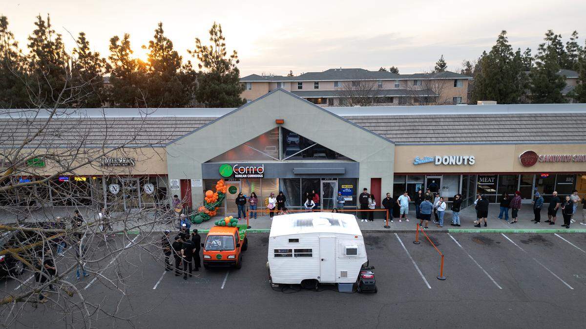People lined up to sample corndogs during the grand opening of Corn’d Korean corn dogs which featured music and a mobile coffee camper in Turlock, Calif., Tuesday, Feb. 13, 2024.