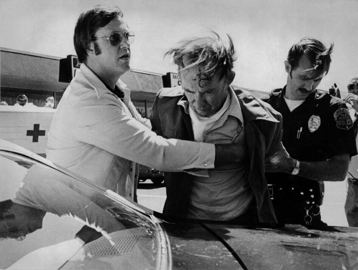 Detective Gary Vance, left, and Officer Bill Hamilton right, take Forrest Tucker into custody at McHenry Village on July 5, 1978.