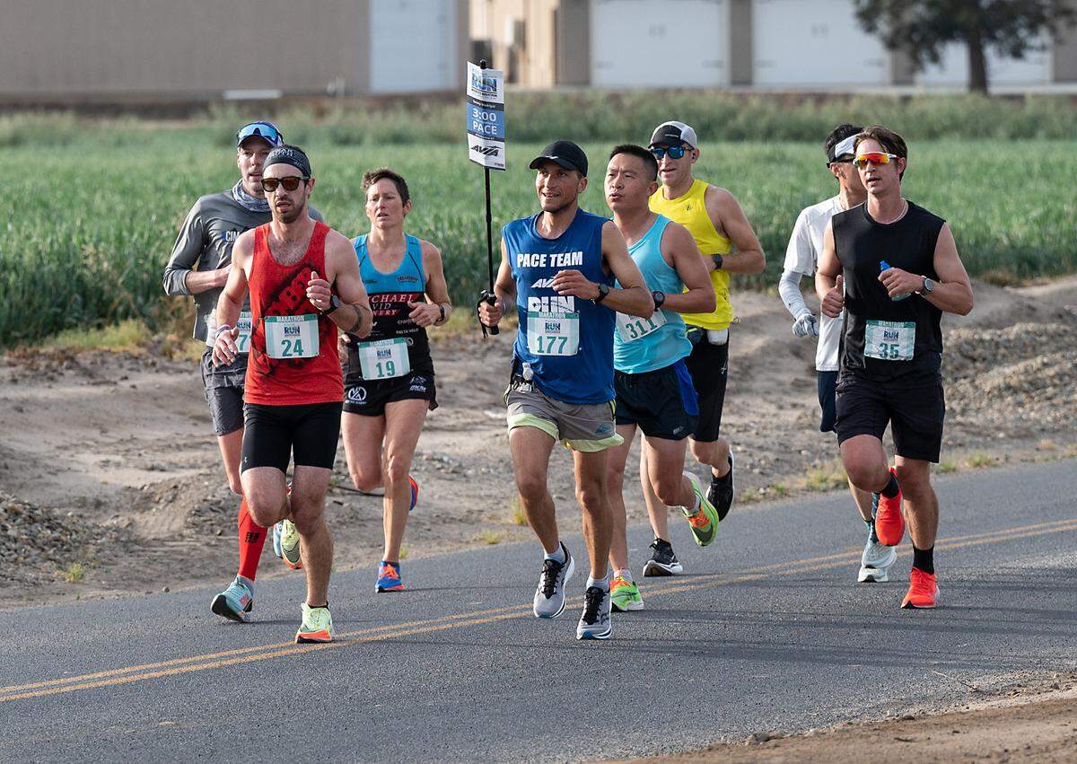 The 3-hour pace group runs on Dunn Road, including the women’s first place finisher Julie Baker (19) of Sonora, during the Modesto Marathon in Modesto, Calif., on Sunday, March 27, 2022. Baker finished with a time of 3:11:15
