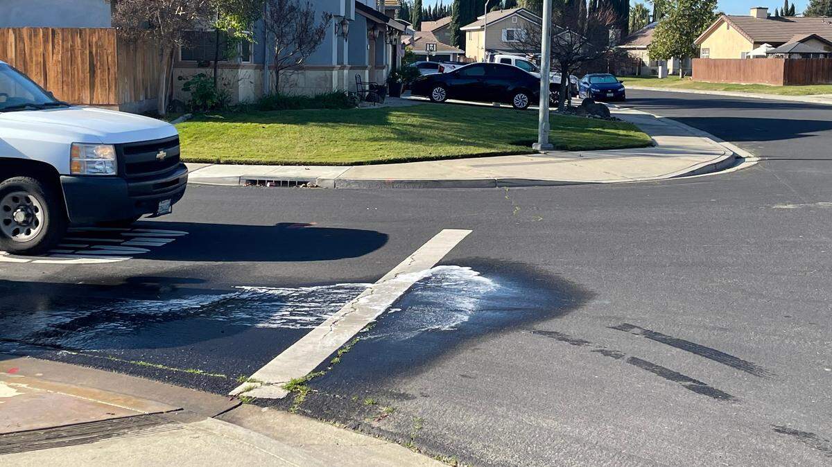 A neighbor washed the street Sunday morning, Jan. 2, 2021, where he found a man shot dead outside his home the night before at the corner of San Martin Court and Pasatiempo Drive in Salida.