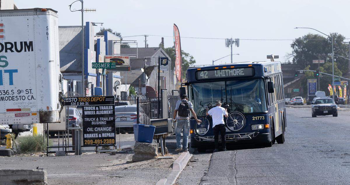 A man loads a bicycle onto a StanRTA bus on South 9th Street in Modesto.