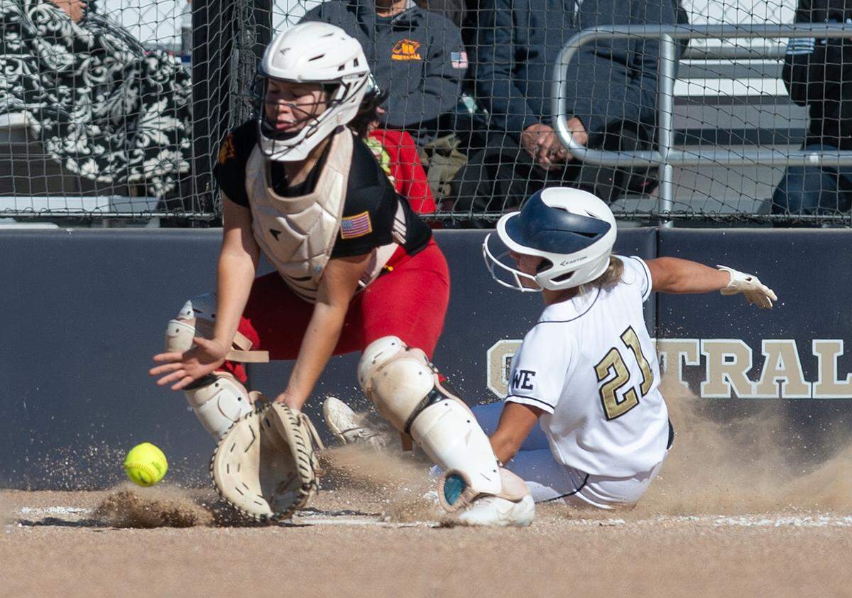 Central Catholic’s Adison Machado scores as she beats the throw to Oakdale catcher Danny Romo at home plate during the Valley Oak League game at Central Catholic High School in Modesto, Calif., on Tuesday, May 10, 2022. Central Catholic won the game 2-1.
