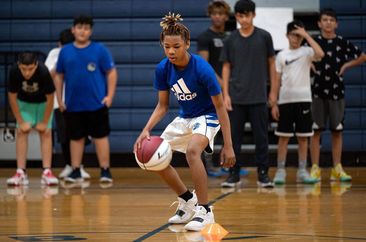 Jameel Harrison, 12, dribbles the ball during a drill at the Modesto Slam-N-Jam basketball camp at Big Valley Christian in Modesto, Calif., on Tuesday, July 5, 2022.
