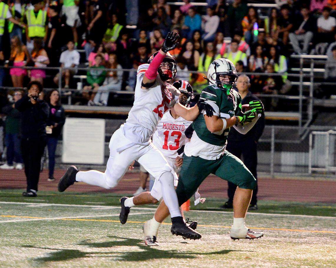 Pitman receiver Jayden Machado (33) catches a touchdown over a Modesto defender during the game with Modesto at Turlock High School in Turlock, Oct. 3, 2025.