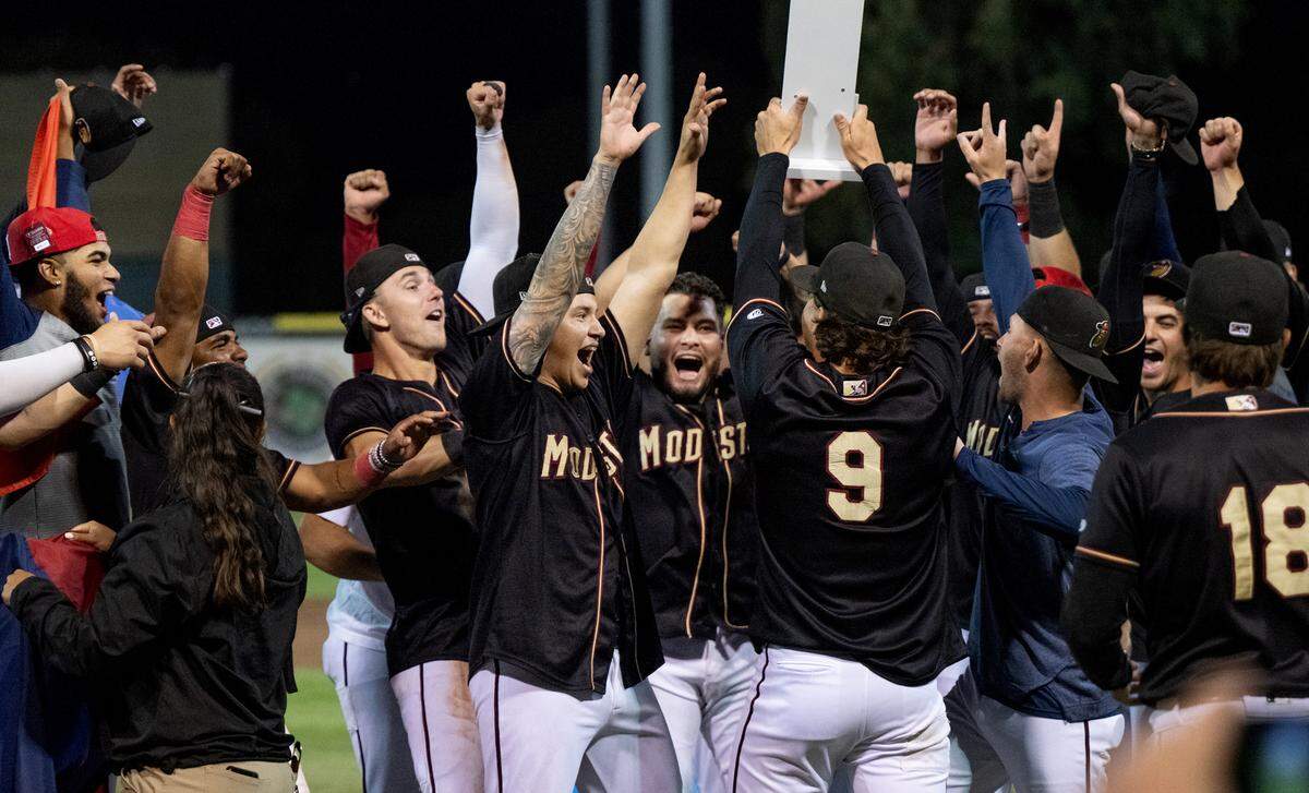 Modesto players celebrate with the California League Championship trophy at John Thurman Field in Modesto, Calif., Wednesday, Sept. 18, 2024.