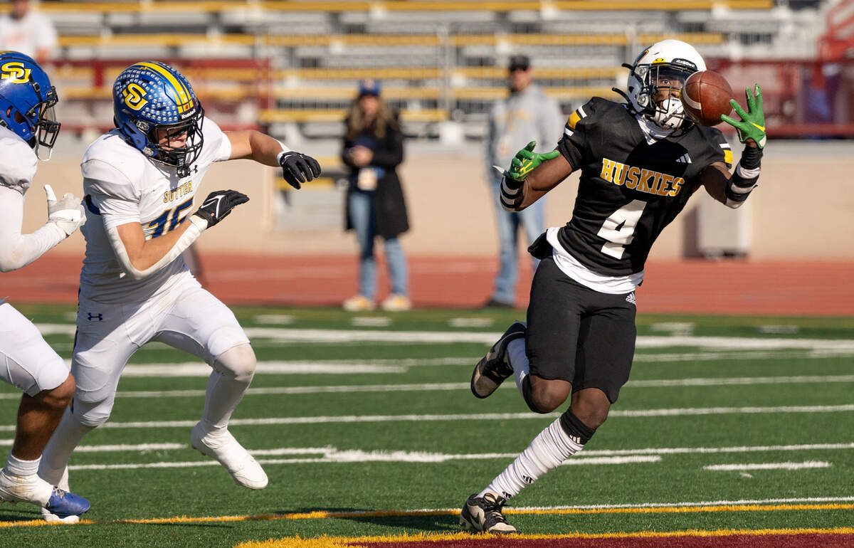 Hughson’s Malakai Sumter makes a reception past Sutter defenders during the Sac-Joaquin Section Division 5 championship game at Sacramento City College in Sacramento, Saturday, Nov. 30, 2024.