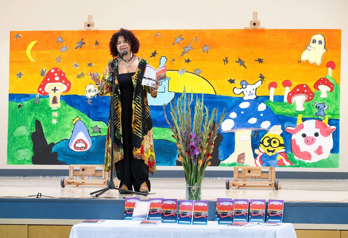 Poet Vielka Solano speaks during a assembly presenting the poetry and art created by students during an after-school program at Bret Harte Elementary School in Modesto, Calif., Wednesday, May 22, 2024.