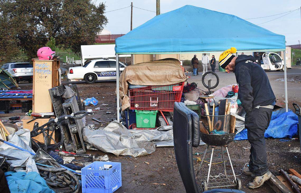 Tyler Siemens, 35, prepares to burn some scrap wood as he breaks camp on Wednesday, Dec. 11, 2019, the closing day of the Modesto Outdoor Emergency Shelter next to and beneath the Ninth Street bridge.