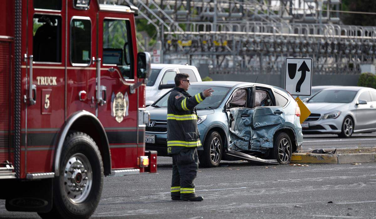 A Modesto firefighter directs motorists after a crash on Coffee Road and Briggsmore Avenue in Modesto, Calif., on Thursday, May 5, 2022.