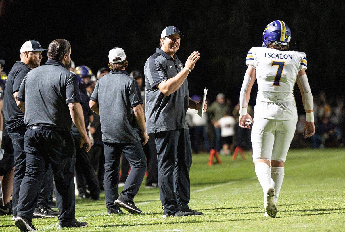 Escalon coach Andrew Beam talks with quarterback Donovan Rozevink during the Trans Valley League game with Hughson in Hughson, Calif., Friday, Sept. 29, 2023.