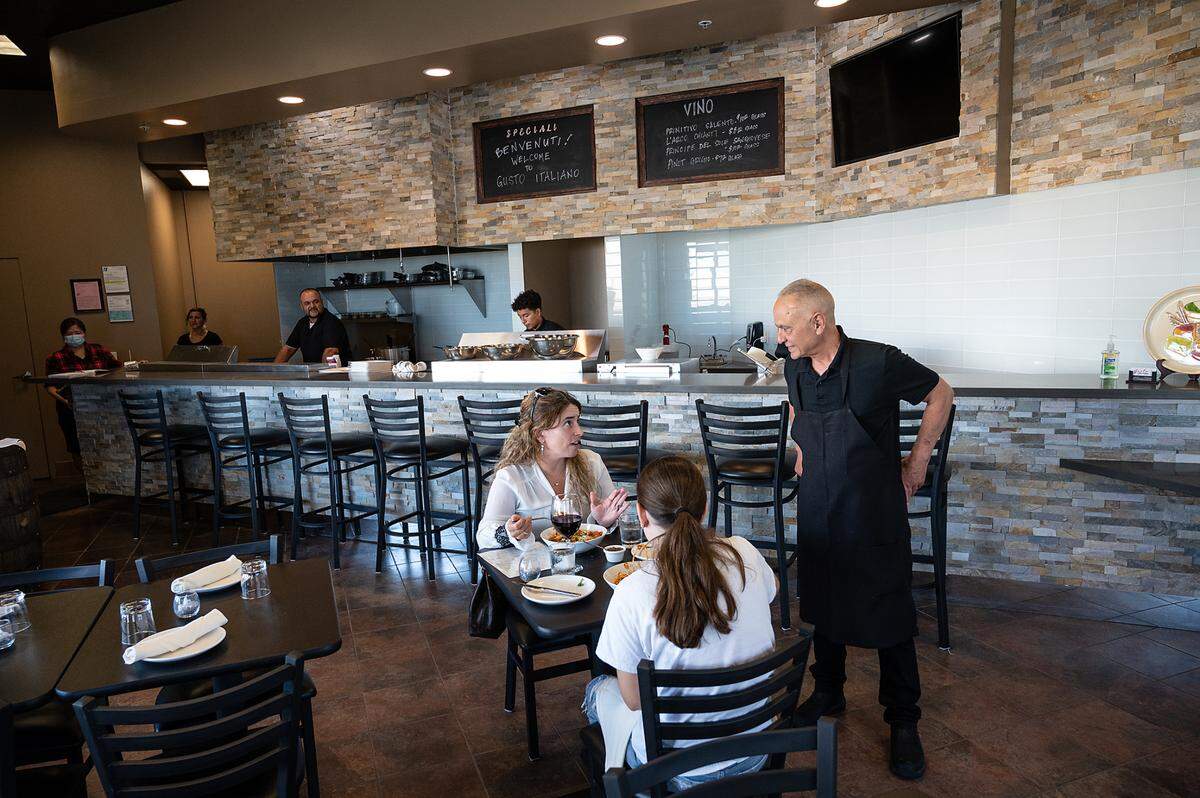 Owner Calogero Sacco talks with diners Flavia Cruz and her daughter Lily, 14, at Gusto Italiano in Modesto, Calif., on Thursday, July 22, 2021.