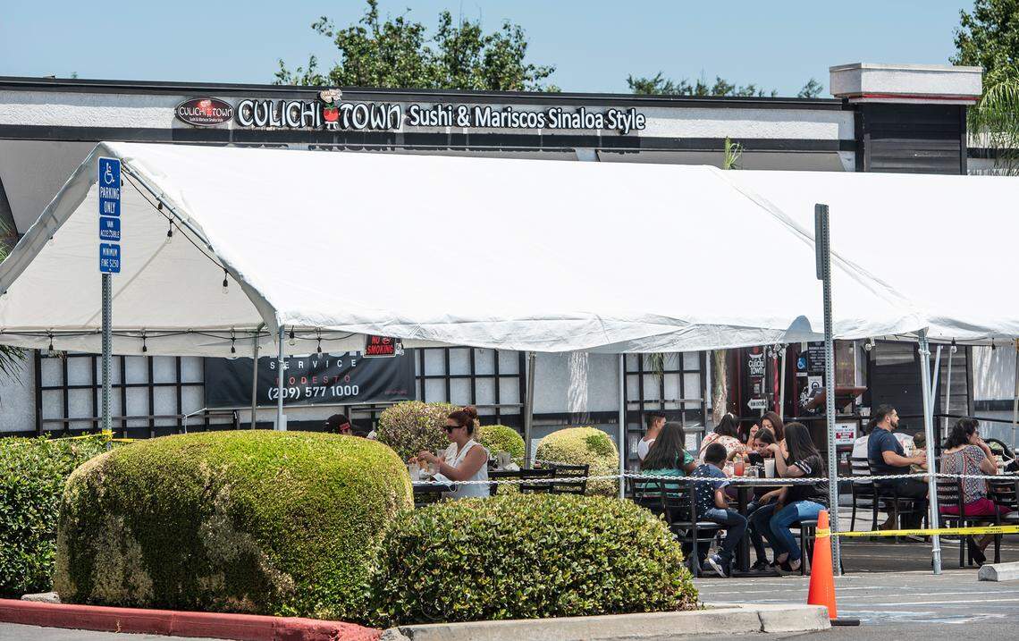 Customers eat lunch outside Culichi Town restaurant on Dale Road in Modesto, Calif., on Wednesday, July 15, 2020.