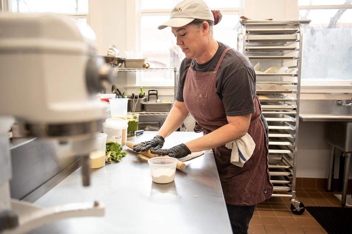 Cook Lacey Gonzalez rolls out flat bread dough at Relish eatery on Main Street in Escalon, Calif., Tuesday, March 21, 2023.