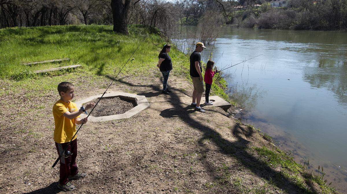 AJ Ruez, 8, left, fishes with others during Modesto Rec Fest at Tuolumne River Regional Park in Modesto, Calif., Saturday, March 16, 2019. 