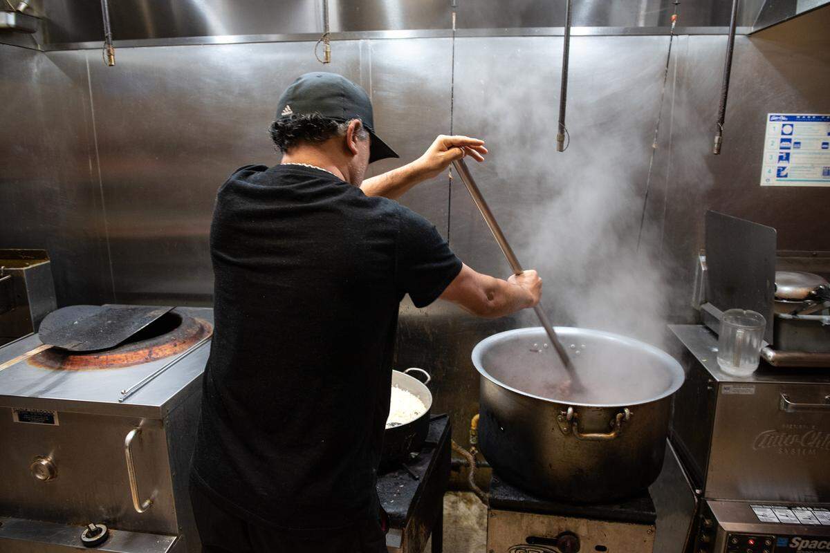 Owner Deepak Dogra prepares chicken curry at Tandoori Masala in Modesto, Calif., Thursday, Dec. 8, 2022.