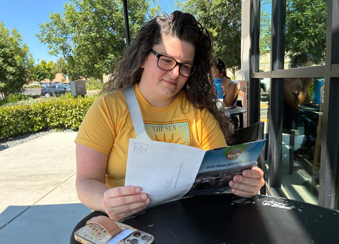 A woman reading at a table outside of a Patterson Starbucks.