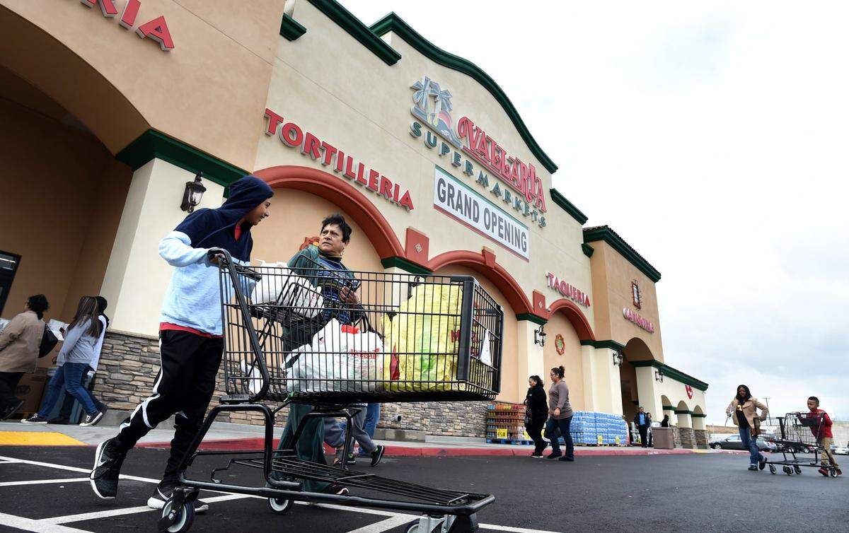 Jose Bravo and grandmother Alexandra Campos leave the new Vallarta Supermarket at Clinton and Weber avenues, after stocking up on groceries in Fresno, Calif., November 2016.