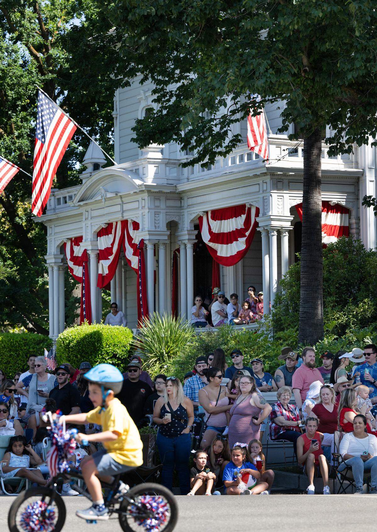 People watch the Independence Day Parade outside McHenry Mansion on I Street in Modesto, Calif., Tuesday, July 4, 2023.