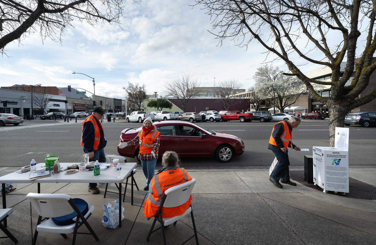Election volunteers collect ballots at a drive-up ballot drop station outside the Gallo Center for the Arts in Modesto, Calif., Tuesday, March 5, 2024.