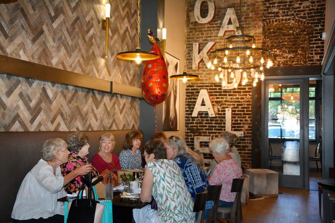 Diners sit underneath the letters spelling “Oakdale” that were once part of the marquee for the former Oakdale Theatre.