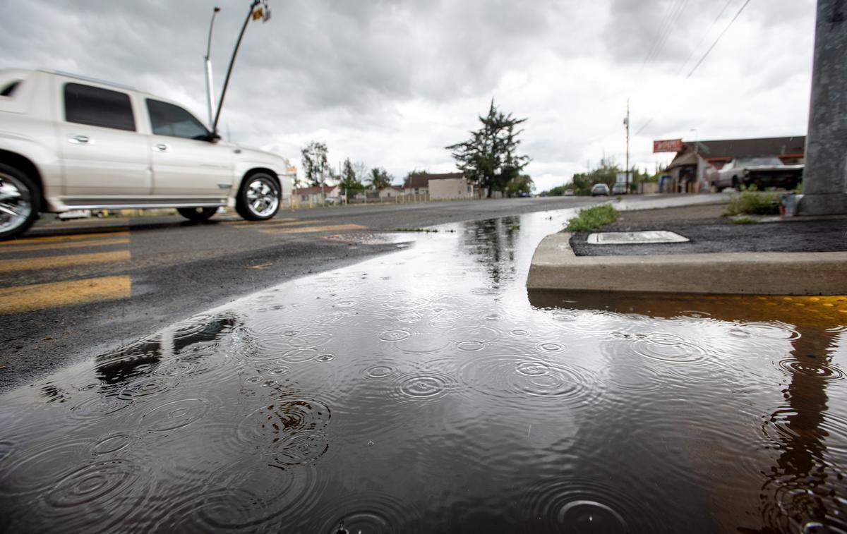 Rain drops can be seen falling in a puddle on Paradise Road in Modesto, Calif., on Monday March 28, 2022.