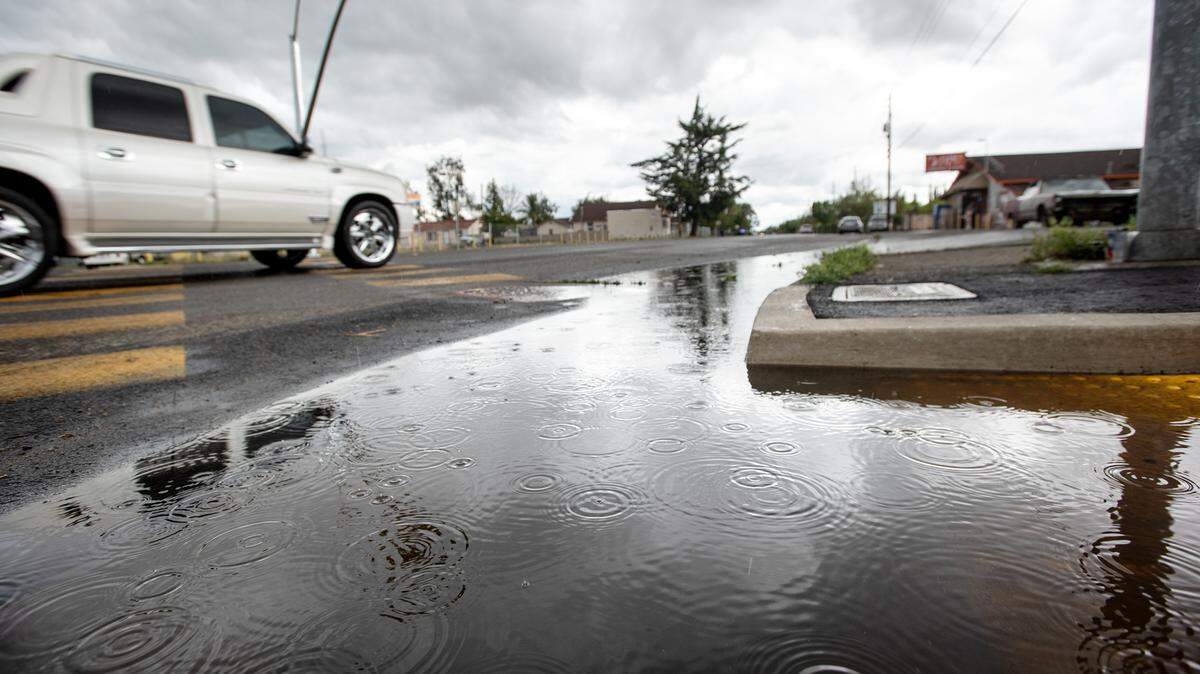 Rain drops can be seen falling in a puddle on Paradise Road in Modesto, Calif., on Monday March 28, 2022.