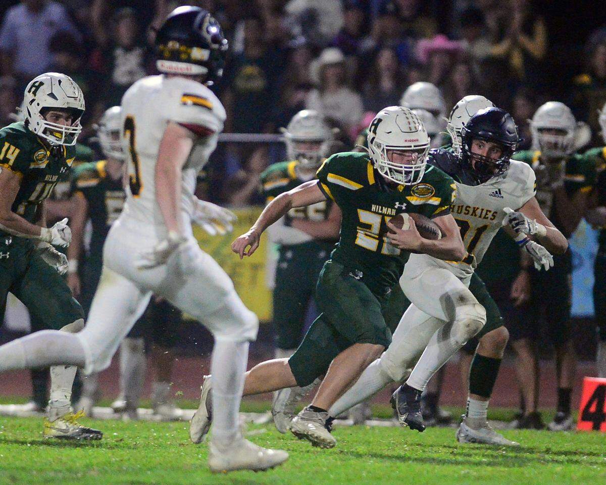 Hilmar quarterback Caden Bailey (22) scrambles upfield during a game between Hughson High School and Hilmar High School at Hughson High School in Hughson CA on October 14, 2022.