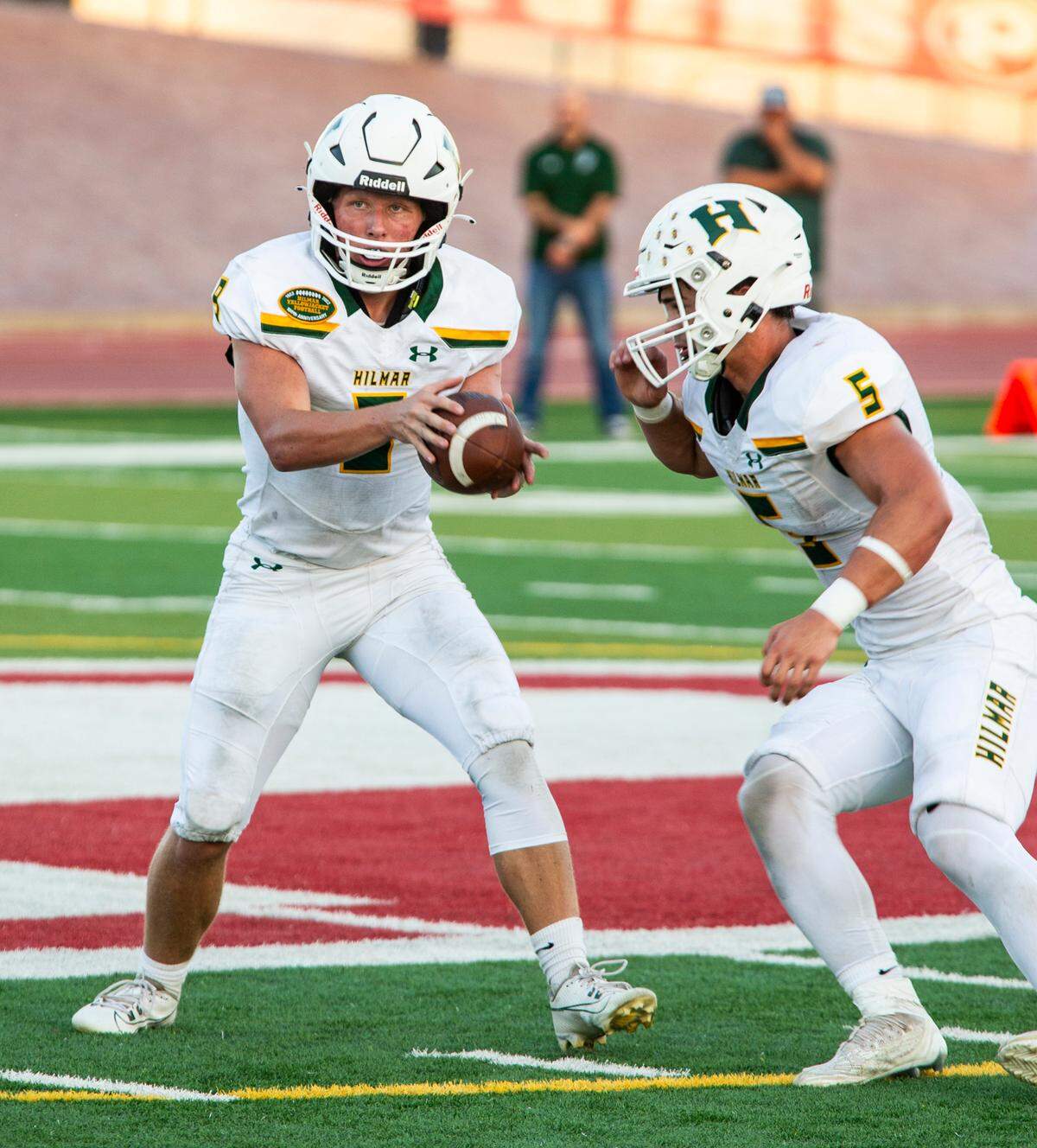Caden Bailey, 9, of Hilmar High hands off the ball to Logan Cardoso, 5, during the first half.
