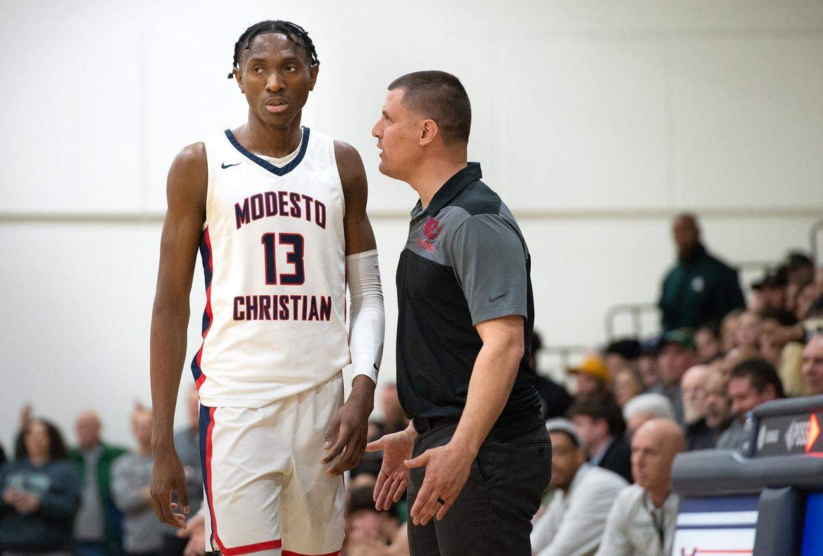 Modesto Christian head coach Brice Fantazia, right, talks with Prince Oseya during the NorCal Open Division semifinal playoff game with De La Salle in Salida, Calif., Saturday, March 4, 2023.