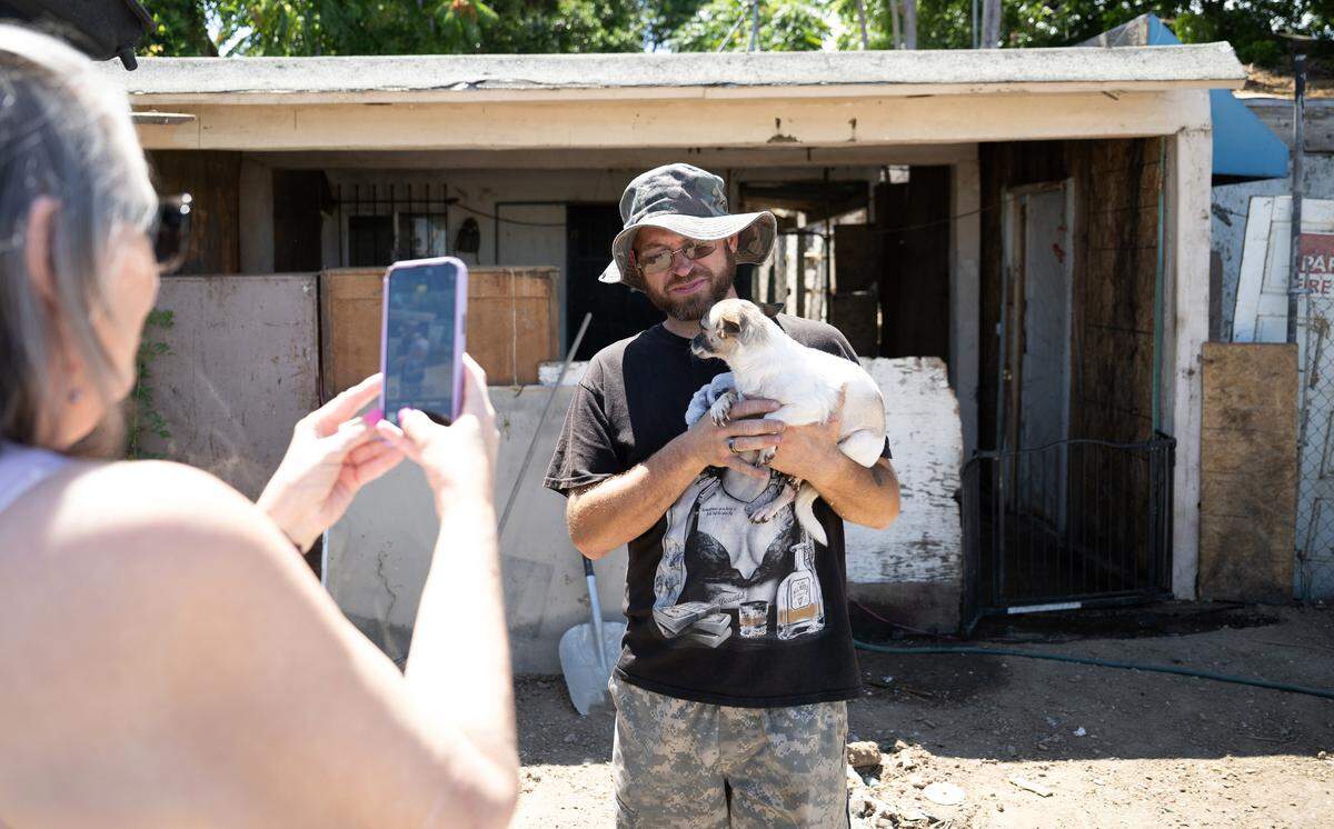 Cynthia Homen from Tiny Paws Oakdale picks up 5 dogs from Alex Aplleby, right, in Modesto Friday, June 13, 2025. Appleby has been rehoming Chihuahuas left behind by his neighbors who died in a car accident.
