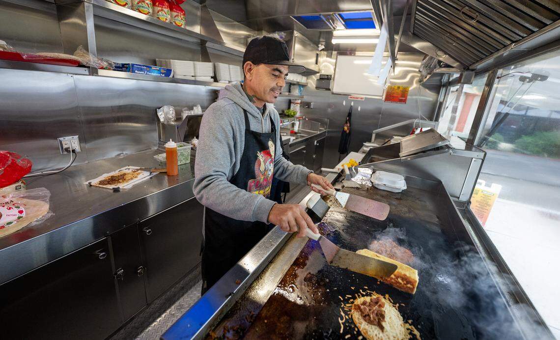 Owner Rafael Calvillo works the grill at Flaco’s Tacos food truck on Coffee Road in Modesto, Monday, Nov. 24, 2025. Calvillo is being forced to change the name of his business due to a trademark conflict.