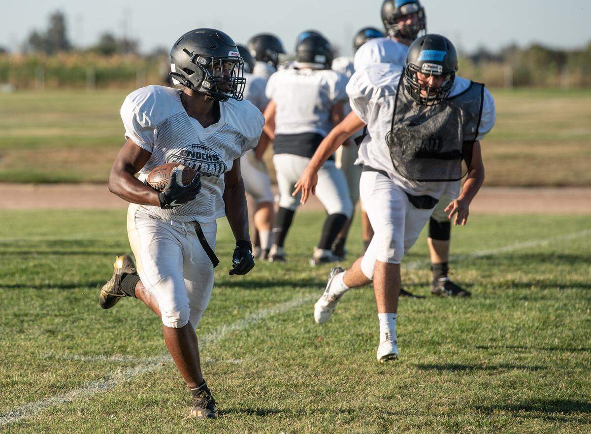 Yomi Babalola runs the ball during practice at Enochs High School in Modesto, Calif., on Wednesday, Sept. 29, 2021.