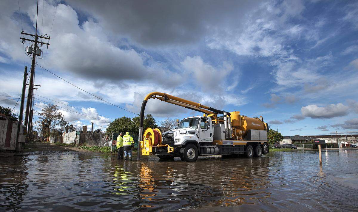Stanislaus County workers pump water from a flooded Church Lane in Modesto, Calif., on Tuesday, Dec. 14, 2021.