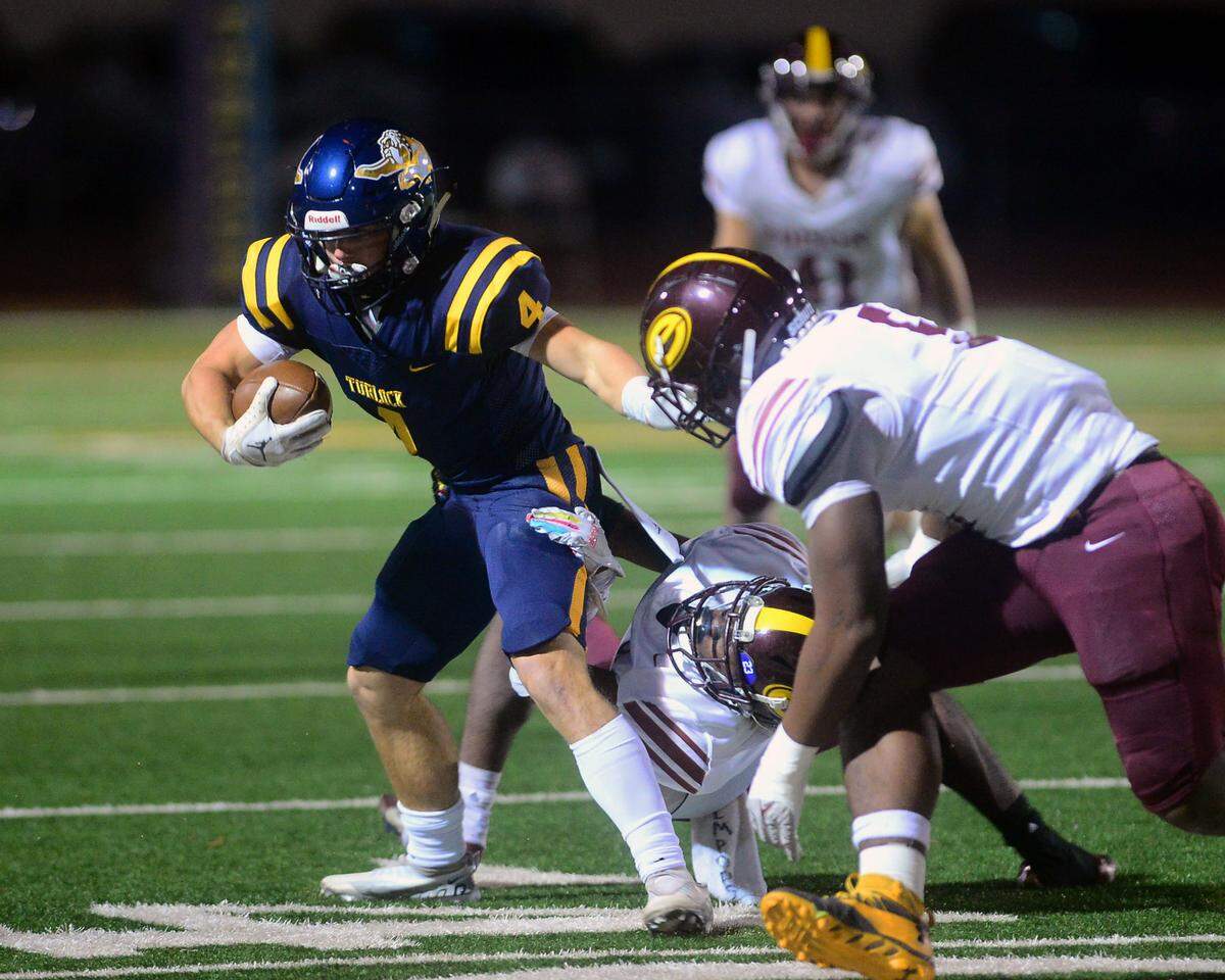Turlock receiver Peter Mello (4) fights off two Edison defenders during a CIF Division I CIF Sac-Joaquin Section Football Playoff game between Turlock High School and Edison High School at Turlock High School in Turlock CA on November 4, 2022. Turlock won 35-0.