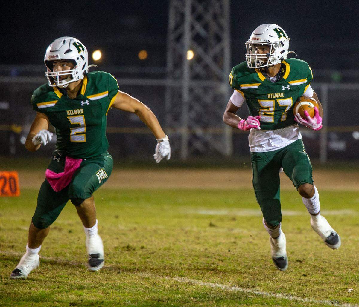 Nathan Ayala, 27, of Hilmar High works his way up field with teammate Roy Guillen, 2, clearing the way during the Trans-Valley League game against Hughson in Hilmar, Calif. on Friday Oct. 25, 2024.